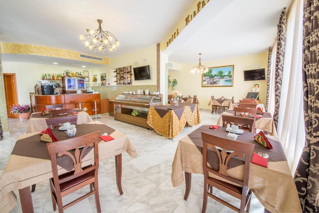 un restaurant avec des tables et des chaises dans une salle dans l'établissement Hotel Salento Mirfran, à Torre San Giovanni