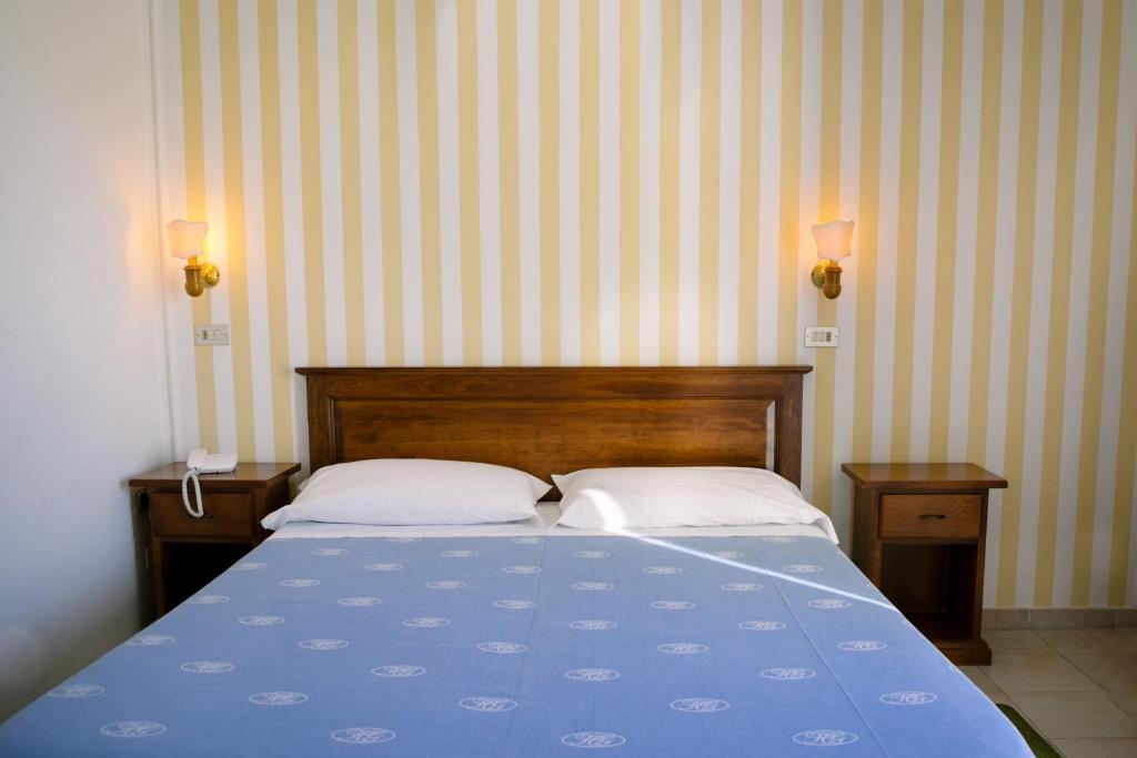 - une chambre avec un lit bleu et 2 oreillers dans l'établissement Hotel Giardino, à Follonica