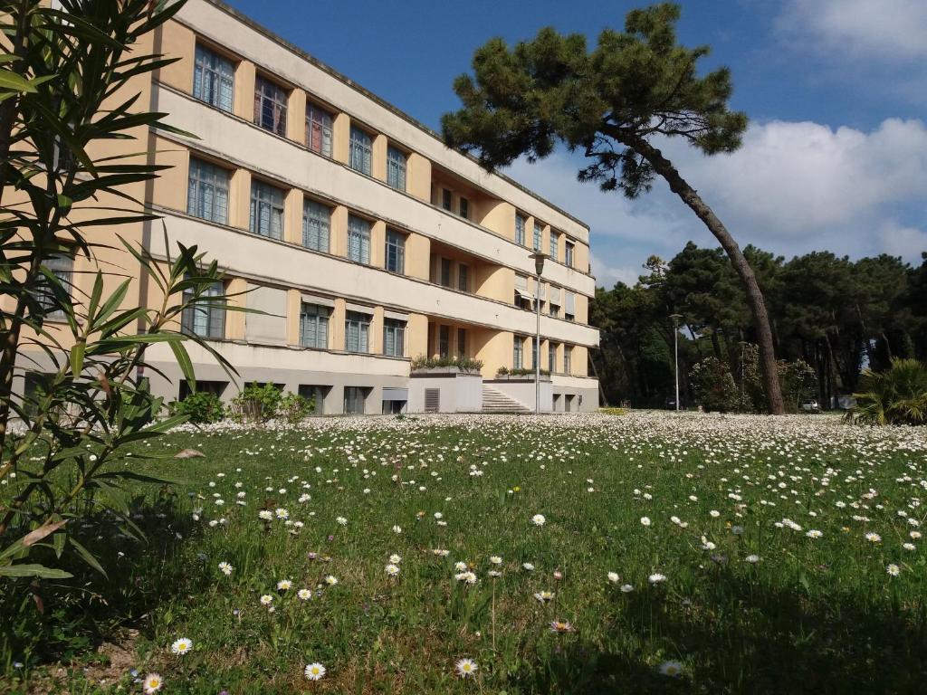 un bâtiment avec un champ de fleurs devant lui dans l'établissement Residence Villa Marina, à Marina di Ravenna