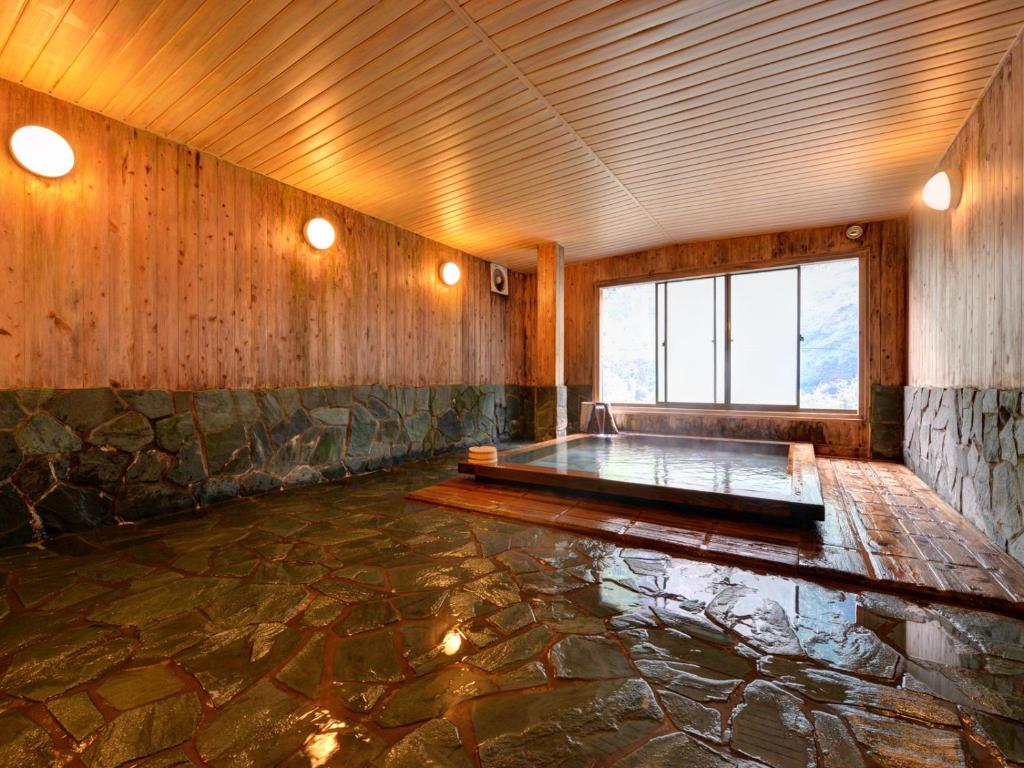 Cette chambre dispose d'un sol en pierre et d'une grande fenêtre. dans l'établissement Kashiwaya Ryokan, à Tenei