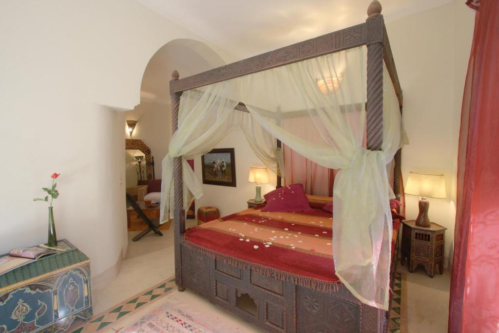 une chambre avec un lit à baldaquin dans une pièce dans l'établissement Riad Cannelle, à Marrakech