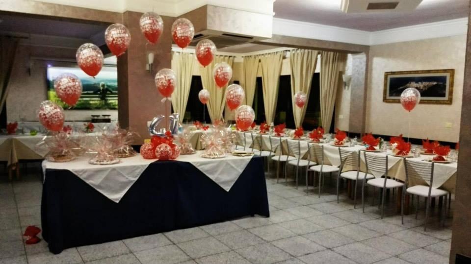 un groupe de tables et de chaises avec ballons rouges et blancs dans l'établissement Hotel Mariagrazia, à Calopezzati