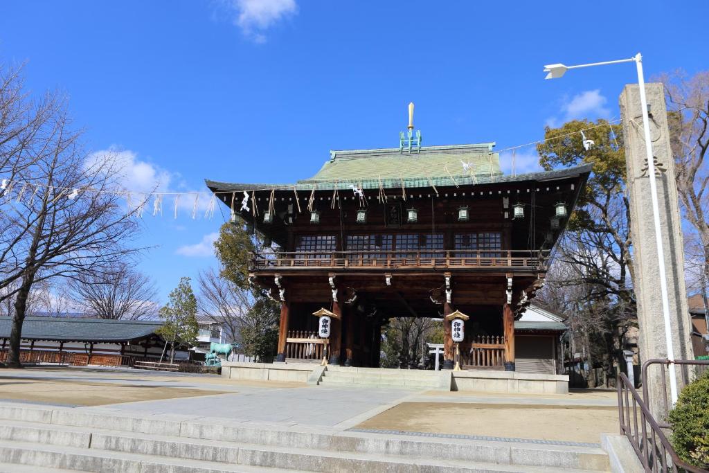 un grand bâtiment en bois avec un toit dans un parc dans l'établissement Hotel La Siena (Adult Only), à Higashiōsaka