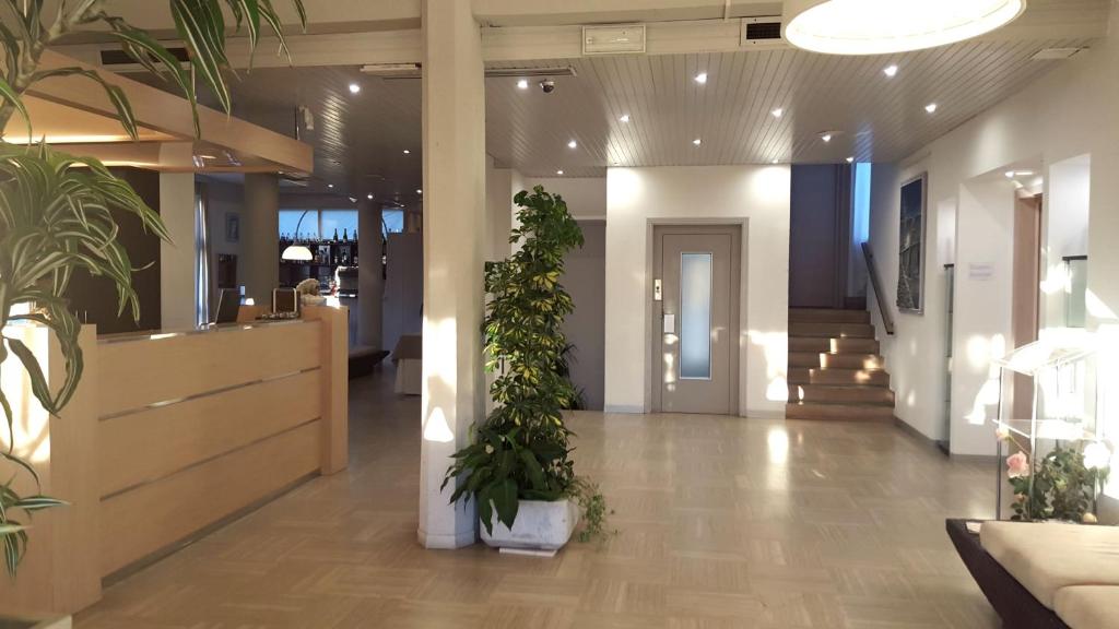 un hall d'entrée avec des plantes en pot dans un immeuble dans l'établissement Hotel Esplanade, à Marina di Pietrasanta 83 autres photos
