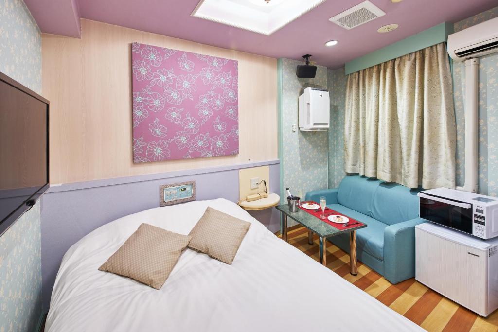 une chambre d'hôpital avec un lit et un canapé dans l'établissement Hotel AQUA Blue Yokosuka (Adult Only), à Yokosuka