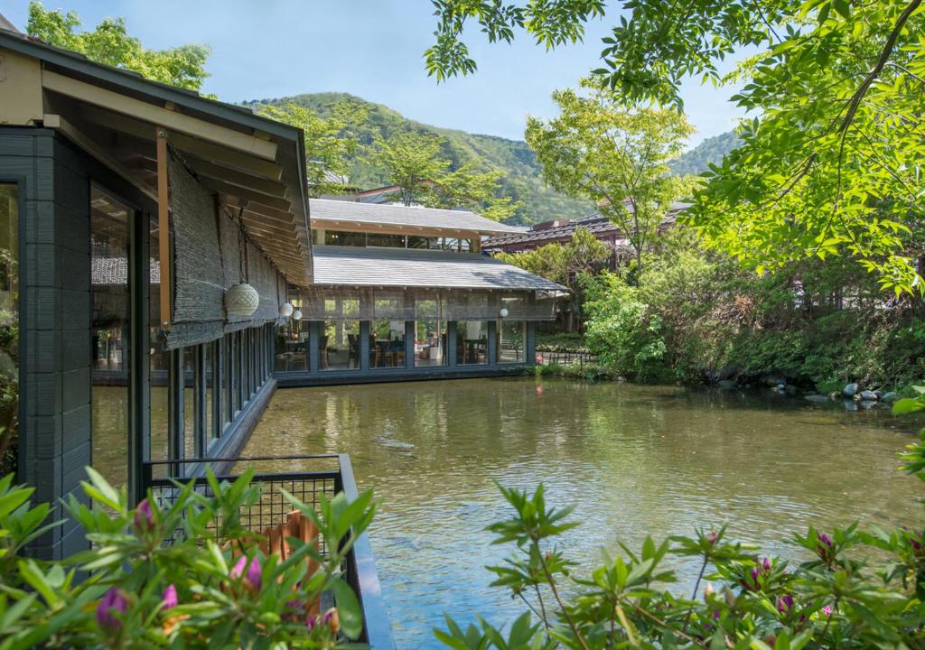 un bâtiment avec une rivière devant lui dans l'établissement Kinugawa Park Hotels, à Nikkō