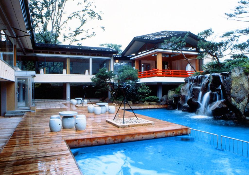 une maison avec une cascade et une piscine dans l'établissement Kinugawa Park Hotels, à Nikkō
