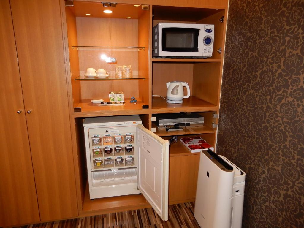une petite cuisine avec un réfrigérateur et un micro-ondes dans l'établissement Hotel Shindbad Aomori -Love Hotel-, à Aomori