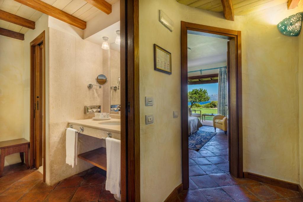 une salle de bain avec un lavabo et un miroir dans l'établissement Hotel Sporting, à Porto Rotondo