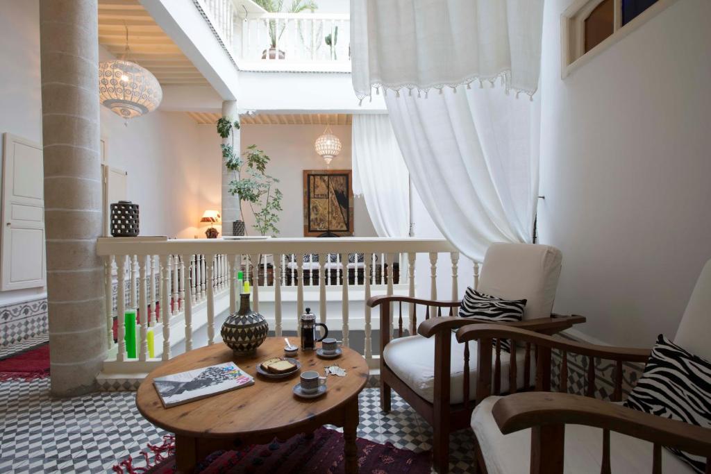 un salon avec une table et une chaise dans l'établissement Riad Emotion, à Essaouira