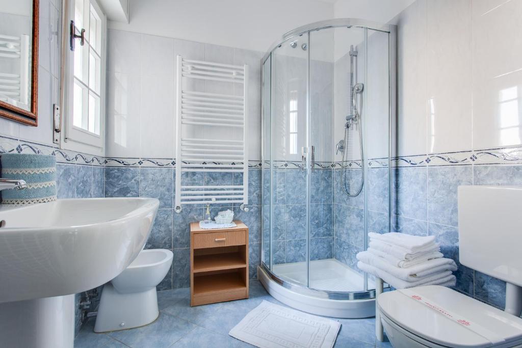 une salle de bain avec une douche, des toilettes et un lavabo dans l'établissement Hotel Villa Pina, à Milano Marittima