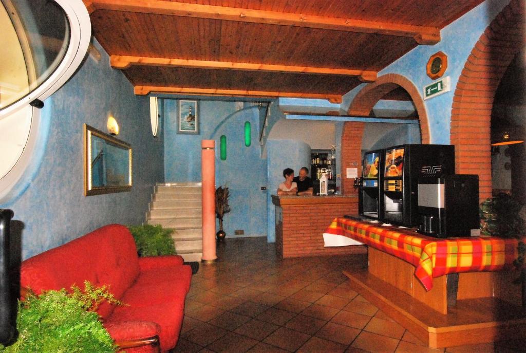 - un salon avec un canapé rouge dans un restaurant dans l'établissement Hotel Cesari, à Rimini