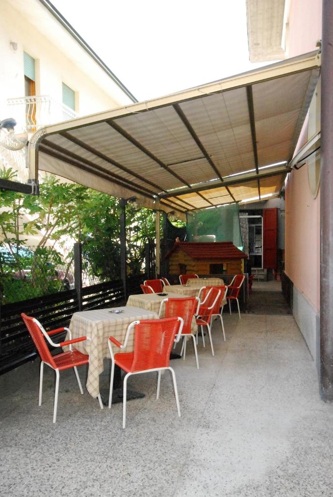 d'une terrasse avec des tables, des chaises et un piano. dans l'établissement Hotel Cesari, à Rimini