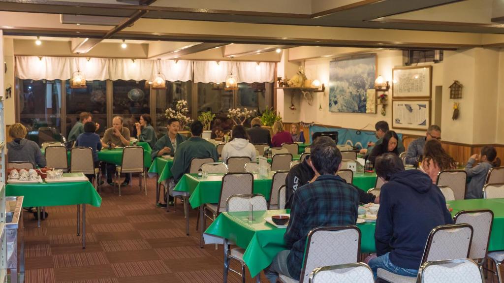 un groupe de personnes assises à des tables dans un restaurant dans l'établissement Aspen Shiga, à Yamanouchi