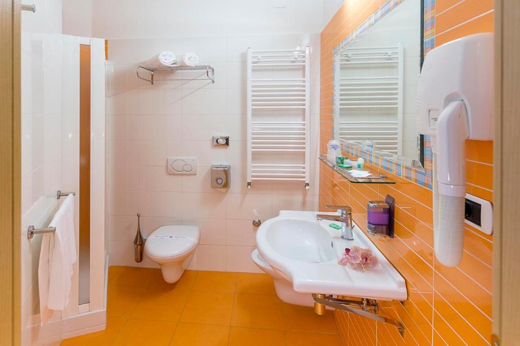 une salle de bain avec un lavabo blanc et des toilettes dans l'établissement Hotel Excelsior, à Alba Adriatica