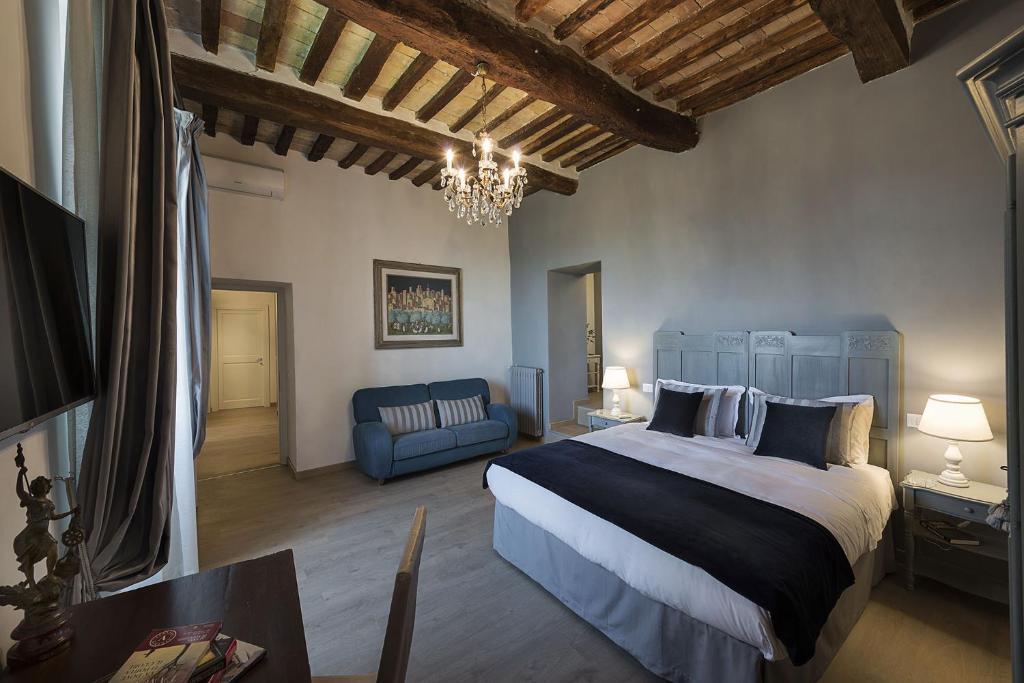 une chambre avec un grand lit et un canapé bleu dans l'établissement Villa Elisa, à Spello