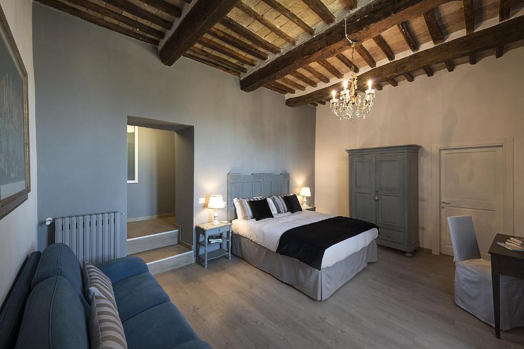 une chambre avec un lit et un canapé bleu dans l'établissement Villa Elisa, à Spello 22 autres photos