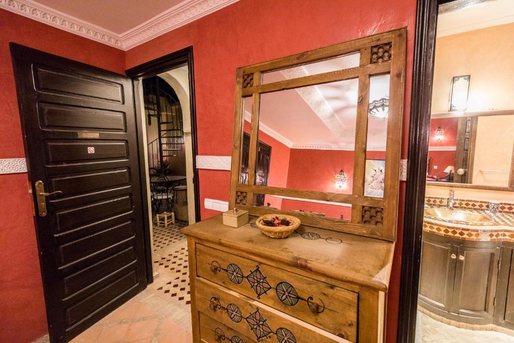 La salle de bains est pourvue d'une commode en bois et d'un miroir. dans l'établissement Riad Atlas Toyours, à Marrakech