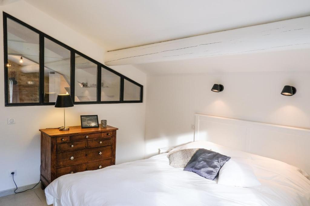 - une chambre avec un lit blanc et une commode en bois dans l'établissement le gîte de Montagnac, à La Roque-sur-Cèze 37 autres photos