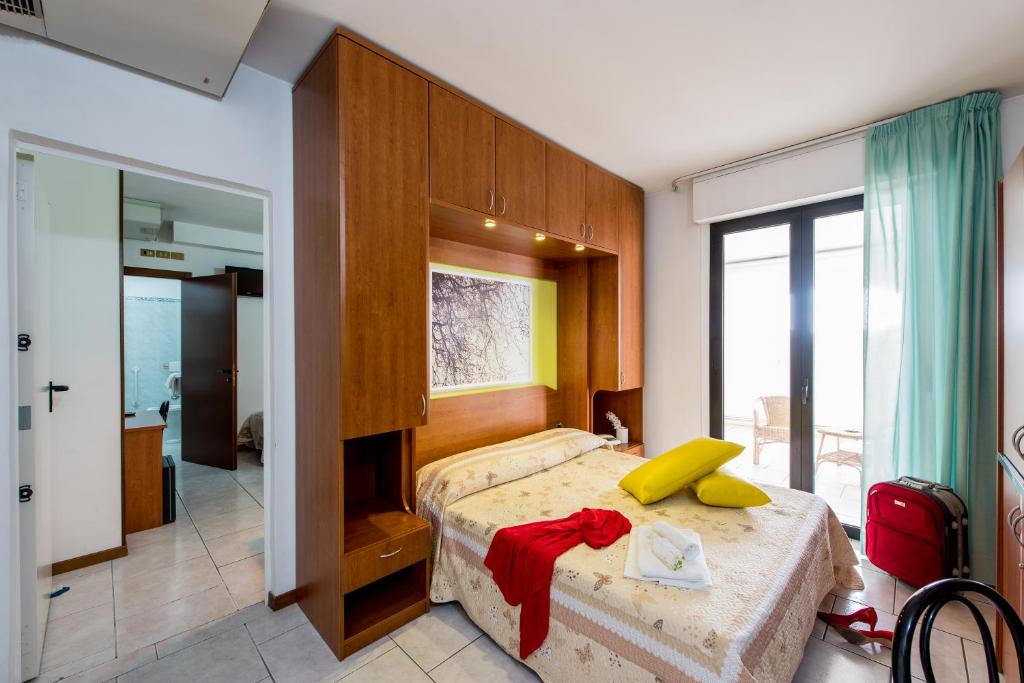 une chambre avec un lit avec des oreillers jaunes dessus dans l'établissement Hotel Villa Truentum, à Martinsicuro