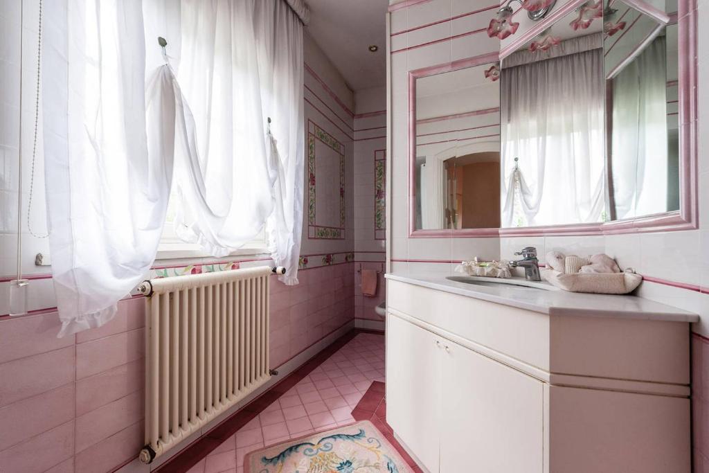 une salle de bain avec un lavabo et un miroir dans l'établissement Villa Bianca, à Lucques