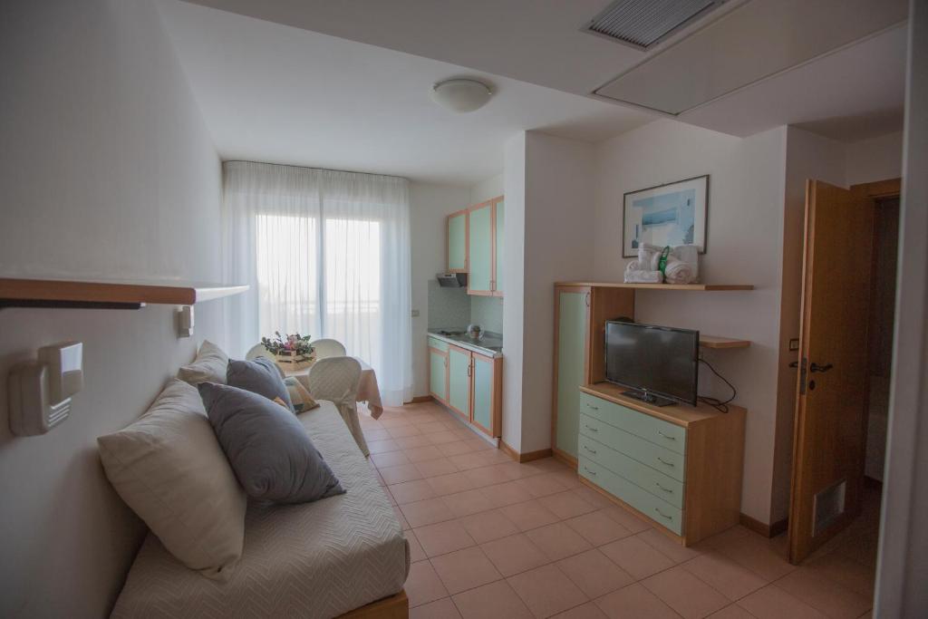 un salon avec un canapé et une télévision dans l'établissement IHR Residence Hotel Le Terrazze, à Grottammare
