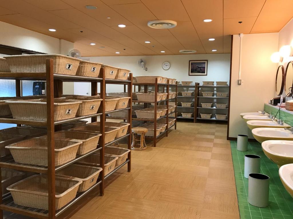 La salle de bains est pourvue de lavabos et d'étagères. dans l'établissement Ohito Hotel, à Izunokuni
