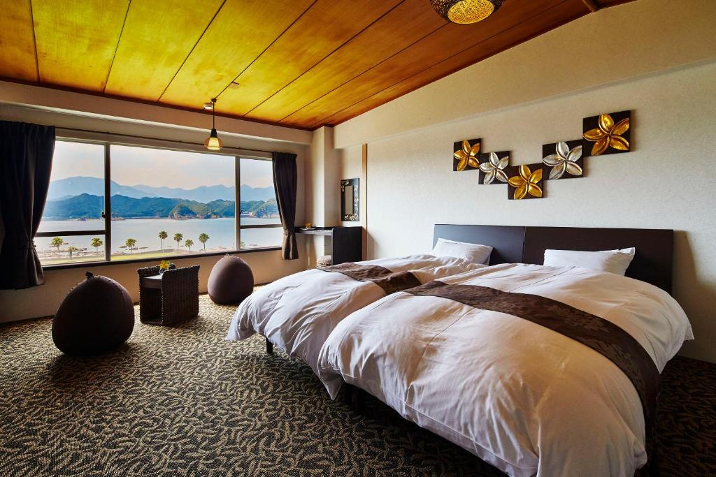 une chambre avec un grand lit et une grande fenêtre dans l'établissement Hana Irodori no Yado Kayuu, à Taiji 37 autres photos