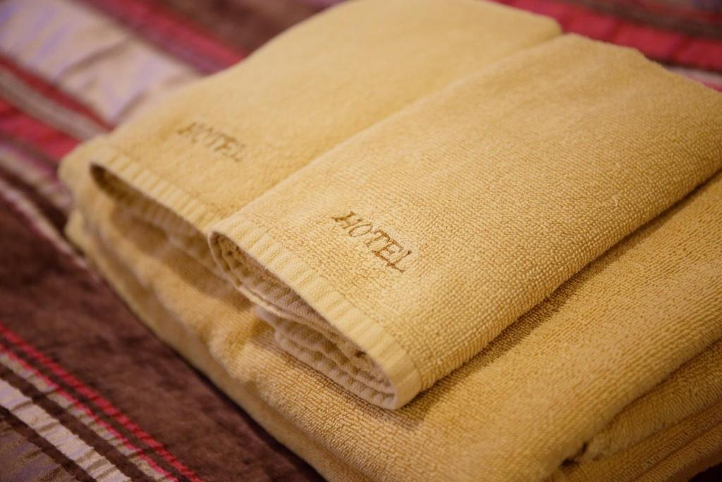 une serviette pliée assise au-dessus d'un lit dans l'établissement Hotel Sunset (Adult Only), à Choshi