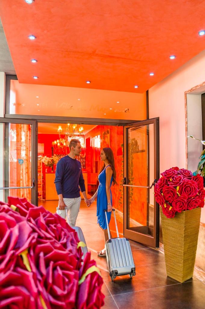 un homme et une femme debout devant un magasin dans l'établissement Hotel Villa Del Mar, à Bibione