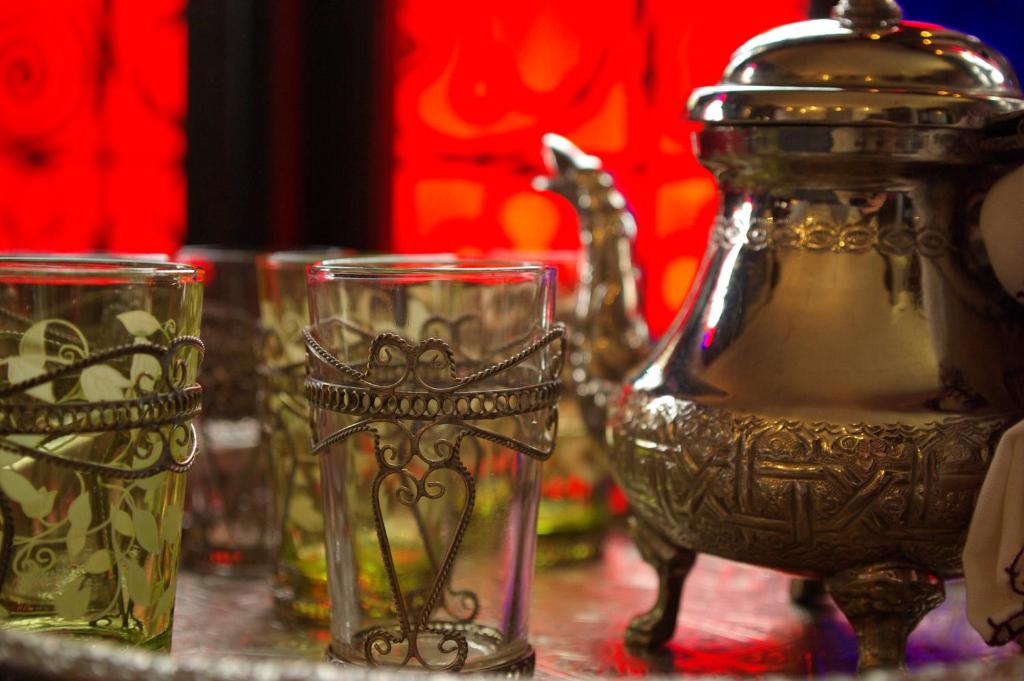 une table avec des verres et une bouilloire dans l'établissement Riad Ibn Battouta & Spa, à Fès