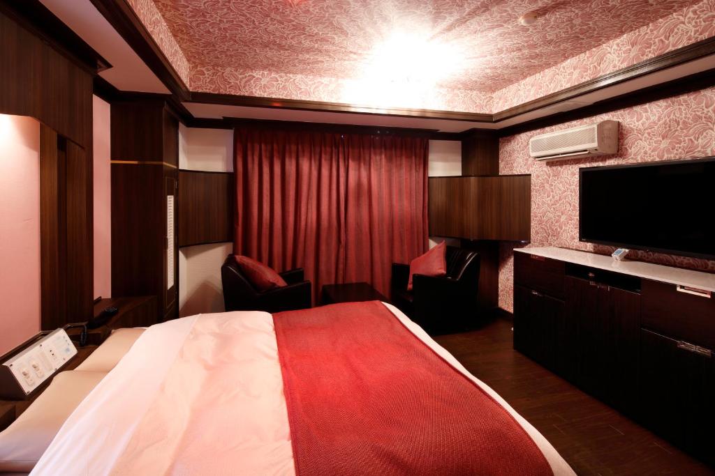 une chambre d'hôtel avec un lit et une télévision à écran plat dans l'établissement Hotel Sunset (Adult Only), à Choshi