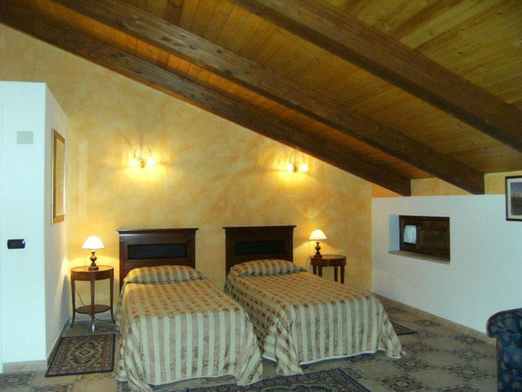 une chambre avec deux lits dans une pièce dans l'établissement Hotel U' Bais, à Scilla