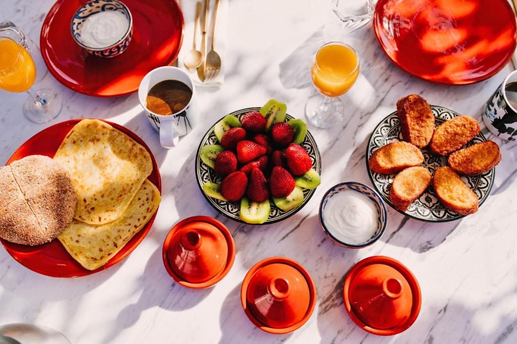 une table recouverte de assiettes de nourriture et de fruits dans l'établissement P´tit Habibi, à Marrakech