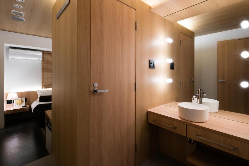 une salle de bain avec un lavabo et un miroir dans l'établissement Hills Hotel Gotanda, à Tokyo