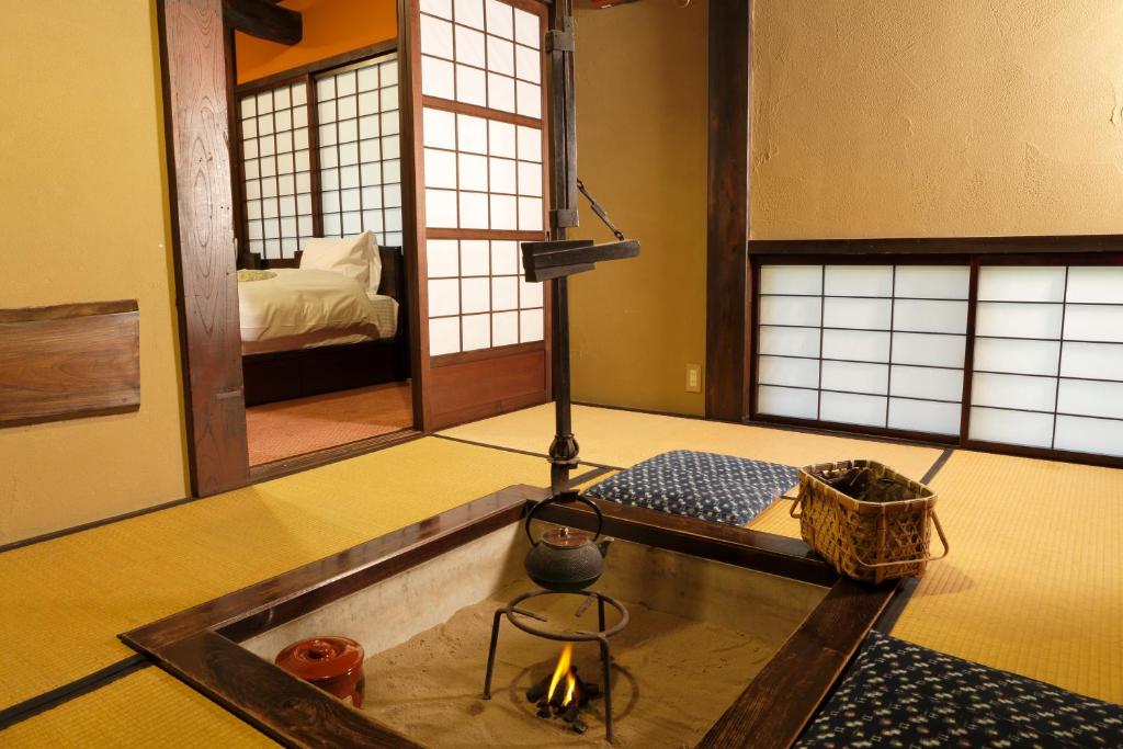 une chambre avec une table et une chambre avec un lit dans l'établissement Yumoto Choza, à Takayama