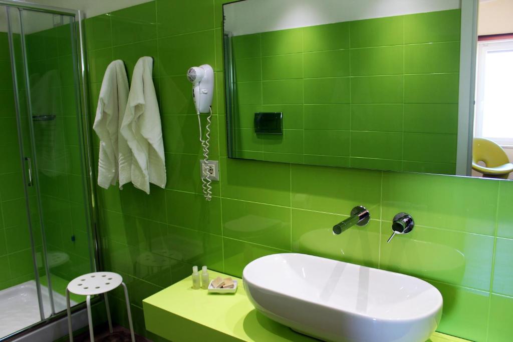 La salle de bains verte est pourvue d'un lavabo et d'un miroir. dans l'établissement Hotel Mare, à Agropoli 36 autres photos