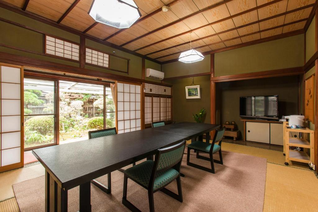 une salle à manger avec une grande table et des chaises noires dans l'établissement Yuuhiken, à Asago