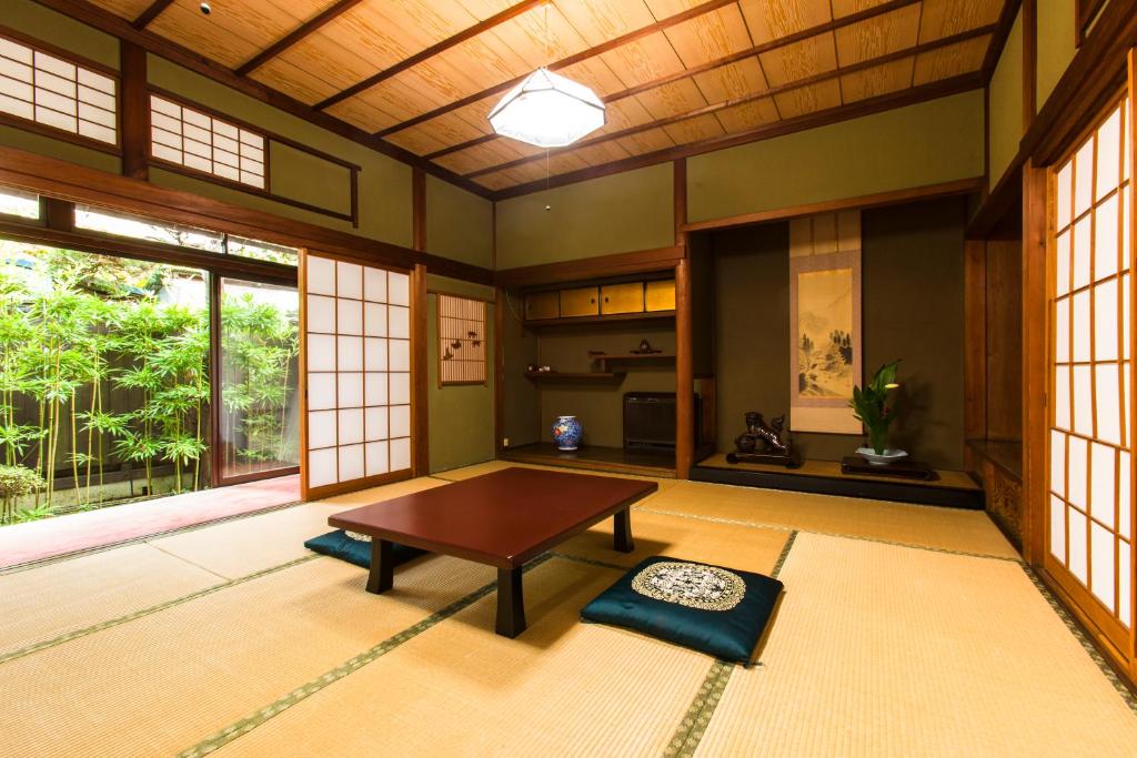 un salon avec une table et une grande fenêtre dans l'établissement Yuuhiken, à Asago