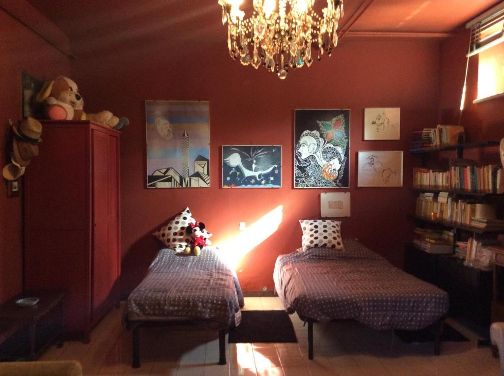 - un salon avec deux lits et un lustre dans l'établissement Villa Nanda a 15 minuti da Roma piscina esclusiva , villa nella natura, à Formello