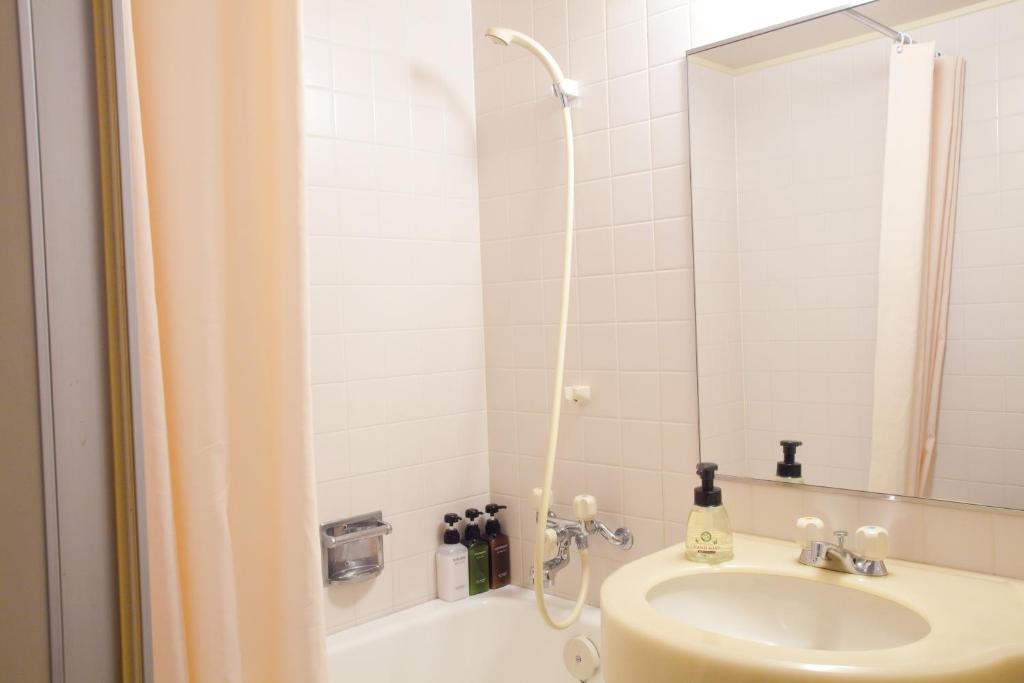 une salle de bain avec un lavabo et une douche avec un miroir dans l'établissement Ranzan, à Kyoto 37 autres photos