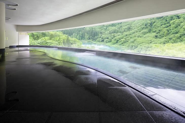 une chambre vide avec vue sur la rivière depuis une fenêtre dans l'établissement Marumine Kanko Hotel, à Aizuwakamatsu