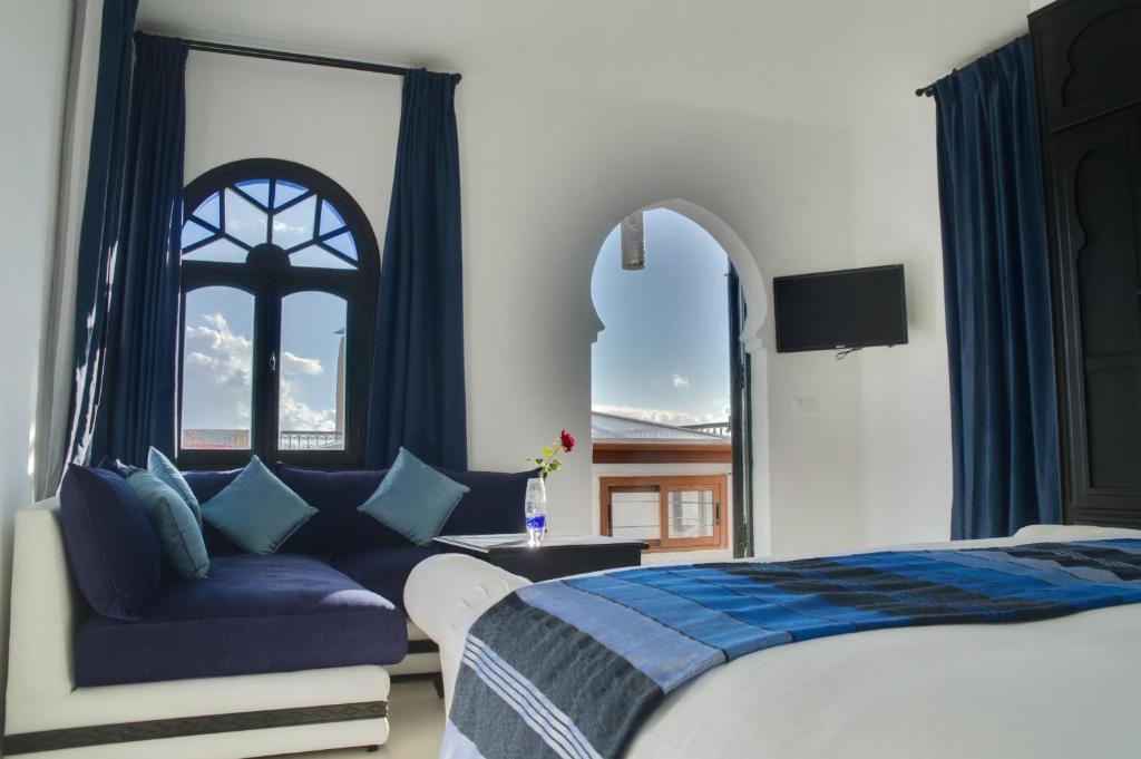une chambre avec un lit, une chaise et une fenêtre dans l'établissement Lina Ryad & Spa, à Chefchaouen