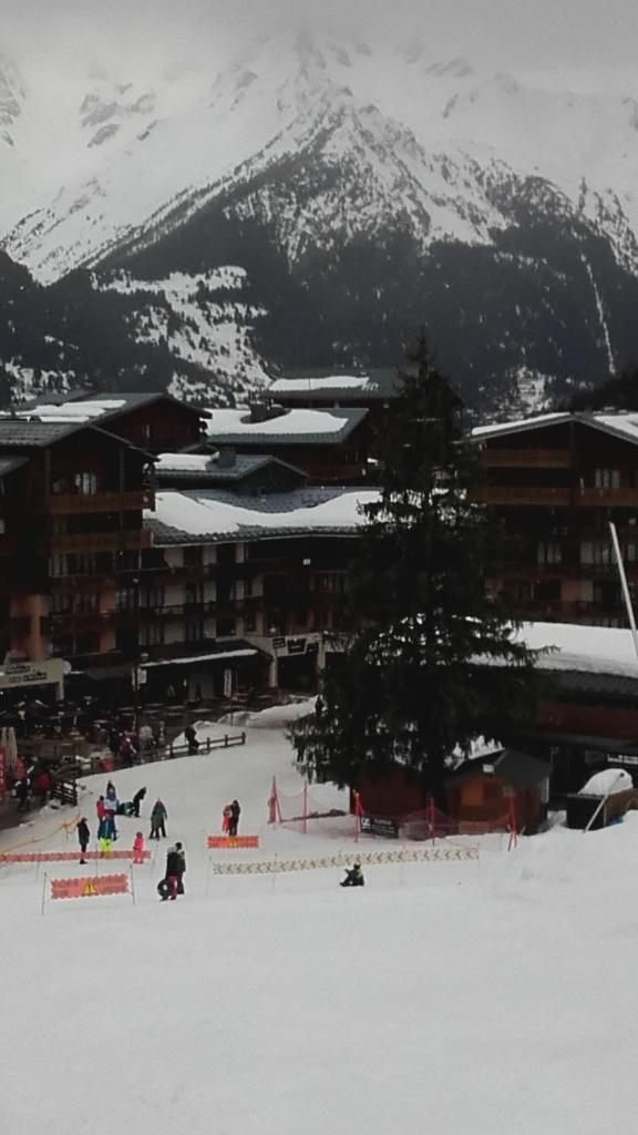 Un groupe de personnes dans la neige devant une montagne dans l'établissement Appartement Valfréjus 5 personnes au pied des pistes, à Valfréjus