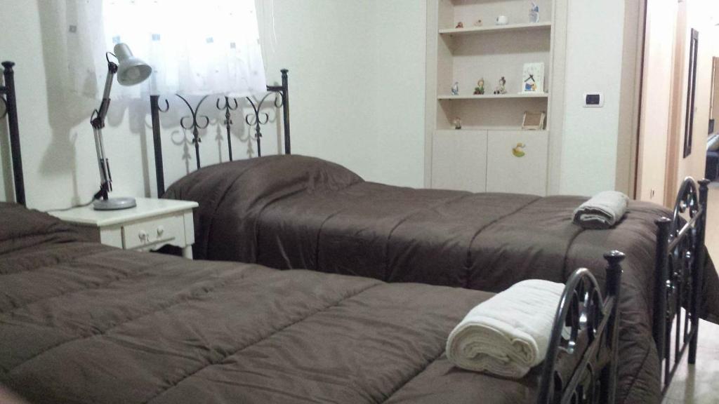 une chambre avec deux lits et une lampe dans l'établissement Villino Michel, à Torre Annunziata