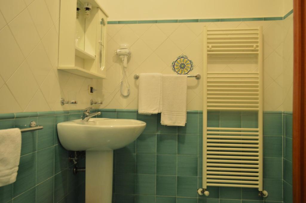 La salle de bains est pourvue d'un lavabo, d'une douche et de serviettes. dans l'établissement B&B Scalea Rooms, à Scalea
