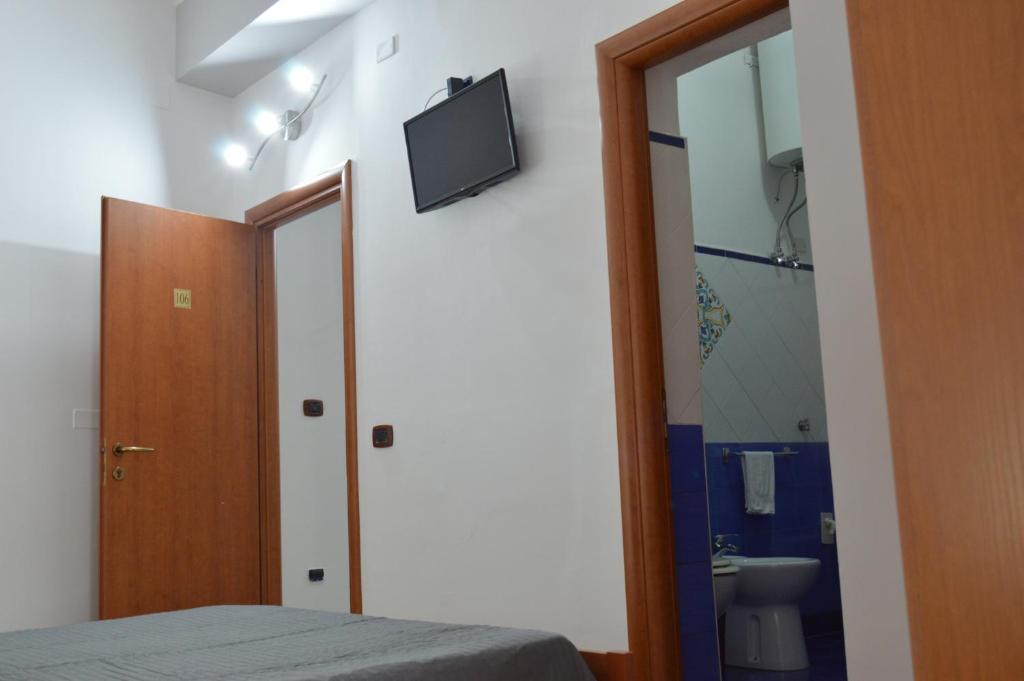 une chambre avec un lit et une télévision au mur dans l'établissement B&B Scalea Rooms, à Scalea 23 autres photos