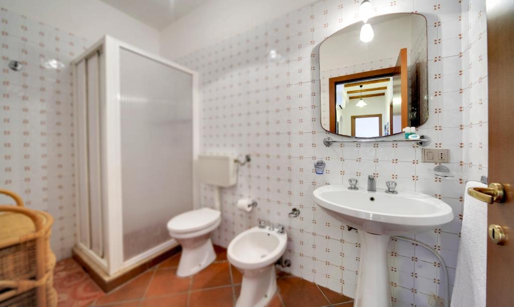 une salle de bain avec un lavabo, des toilettes et un miroir dans l'établissement Villa dell'Ulivo, à Marina di Ragusa