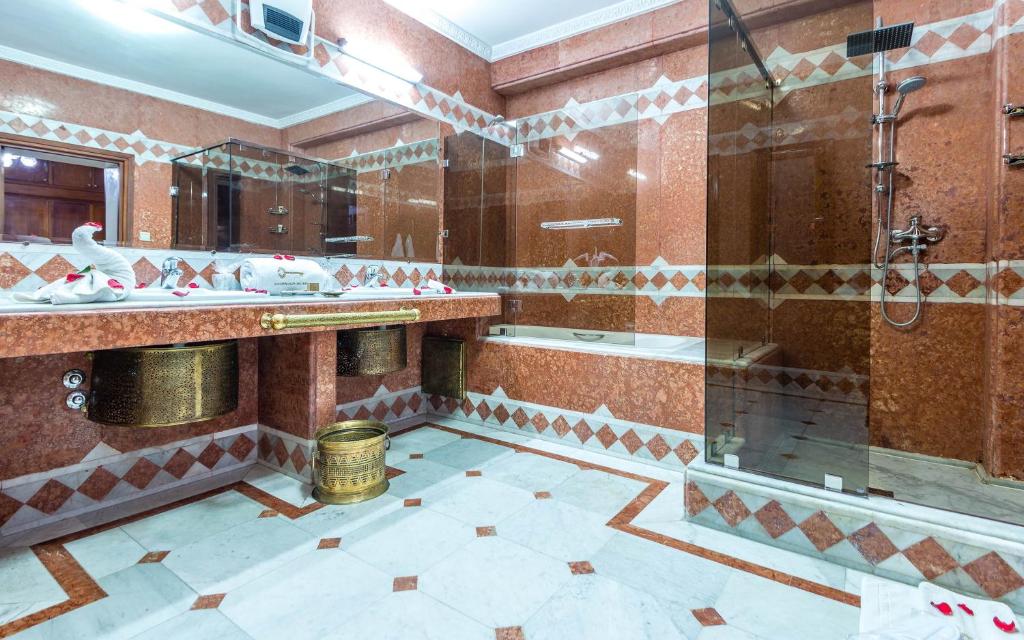 La salle de bains est pourvue d'une douche, de 2 lavabos et d'une baignoire. dans l'établissement Hivernage Secret Suites & Garden, à Marrakech