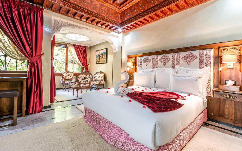 une chambre avec un grand lit blanc dans une pièce dans l'établissement Hivernage Secret Suites & Garden, à Marrakech 40 autres photos